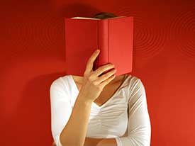Frau liest rotes Buch (dadurch Gesicht verdeckt)