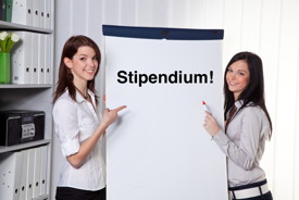 Zwei Studentinnen die auf ein Flipchart mit dem Wort