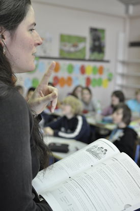 Lehrerin die aus einem Buch unterrichet