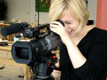 Frau bedient professionelle Videokamera