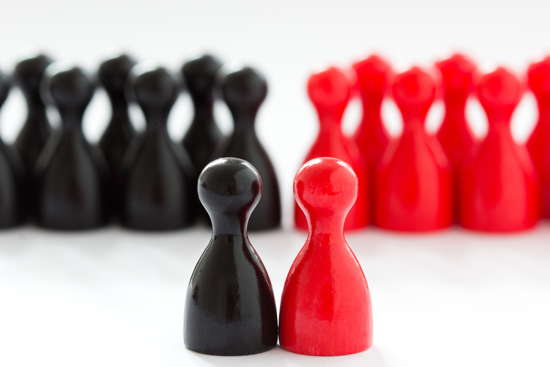 Rote und schwarze Spielfiguren nach Farben gruppiert, je eine rote und schwarze im Vordergrund
