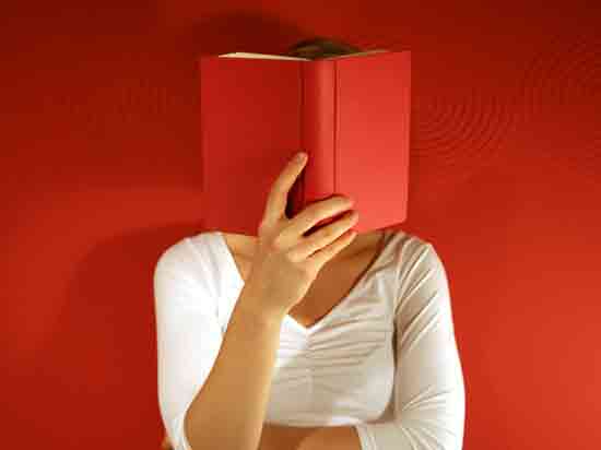 Frau liest rotes Buch (dadurch Gesicht verdeckt)