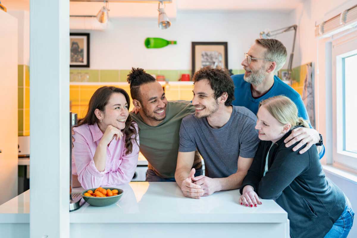 Studierende am Küchentresen lachen