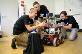 Studierende arbeiten an Roboter