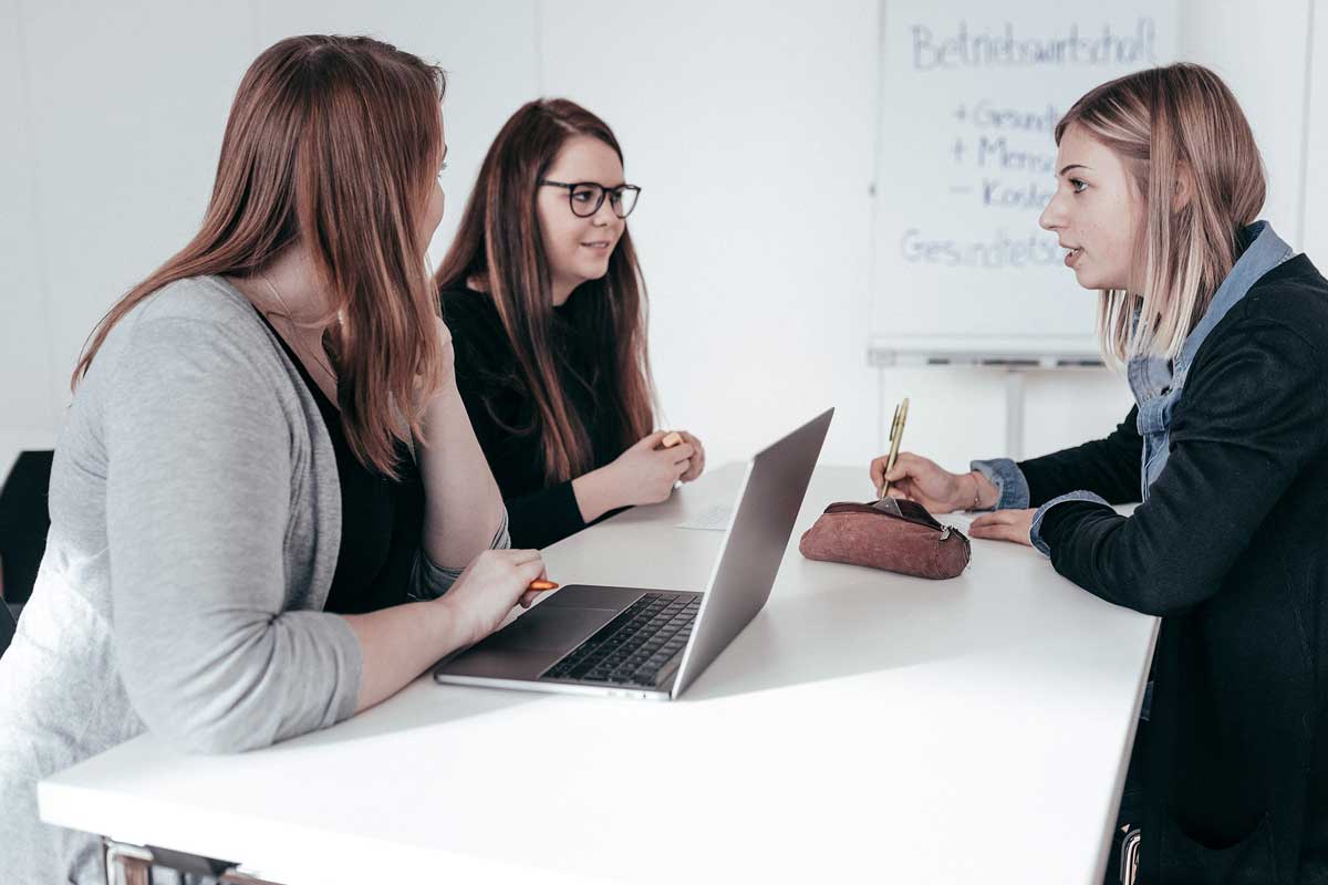 Drei Studentinnen am Tisch