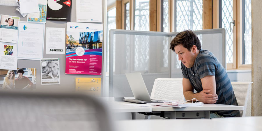 Student grübelt vor dem Laptop