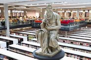 Steinskulptur vor Bücheregalen in der Bereichsbibliothek