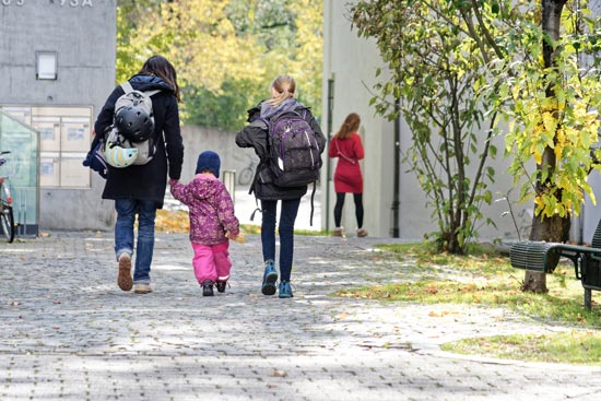 Betreuerin mit zwei Kindern von hinten fotografiert