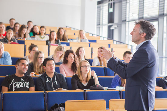 Studenten hören im Hörsaal einem Dozenten zu