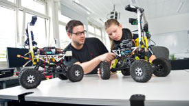 2 Studierende basteln an einem Fahrzeug