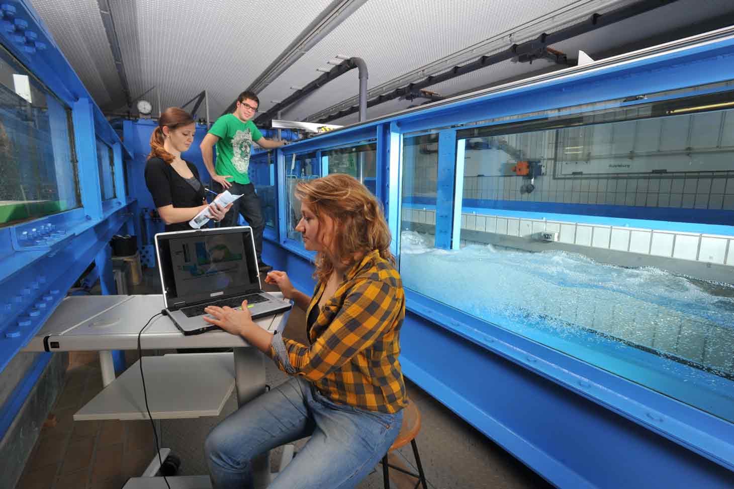 Studierende arbeiten mit Laptop und Wassertank