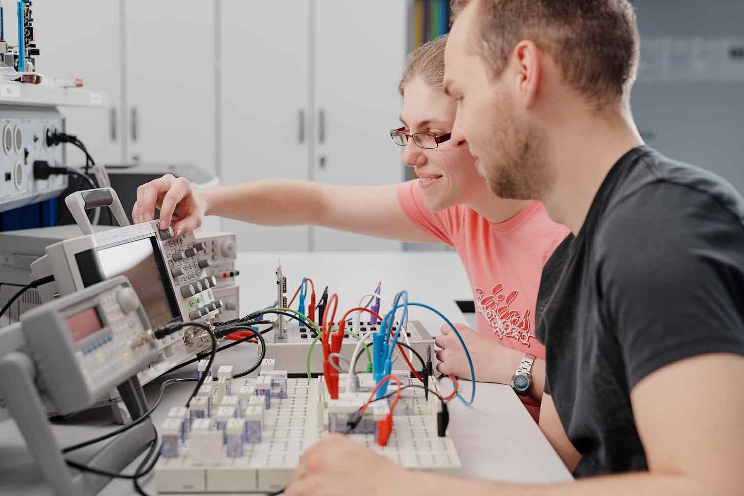 Studierende im Gespräch vor Stecker und Dioden