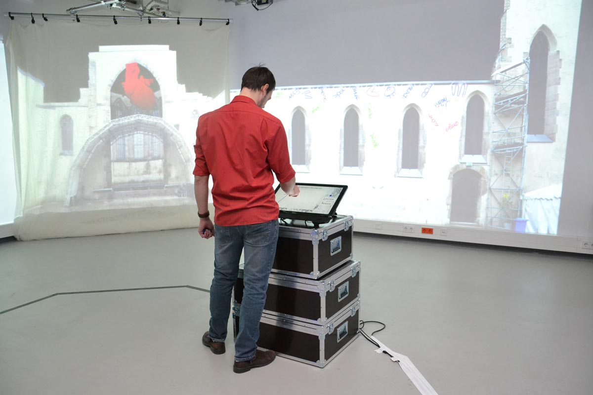 Studierender mit Computerschaltfläche vor Bühnenbild