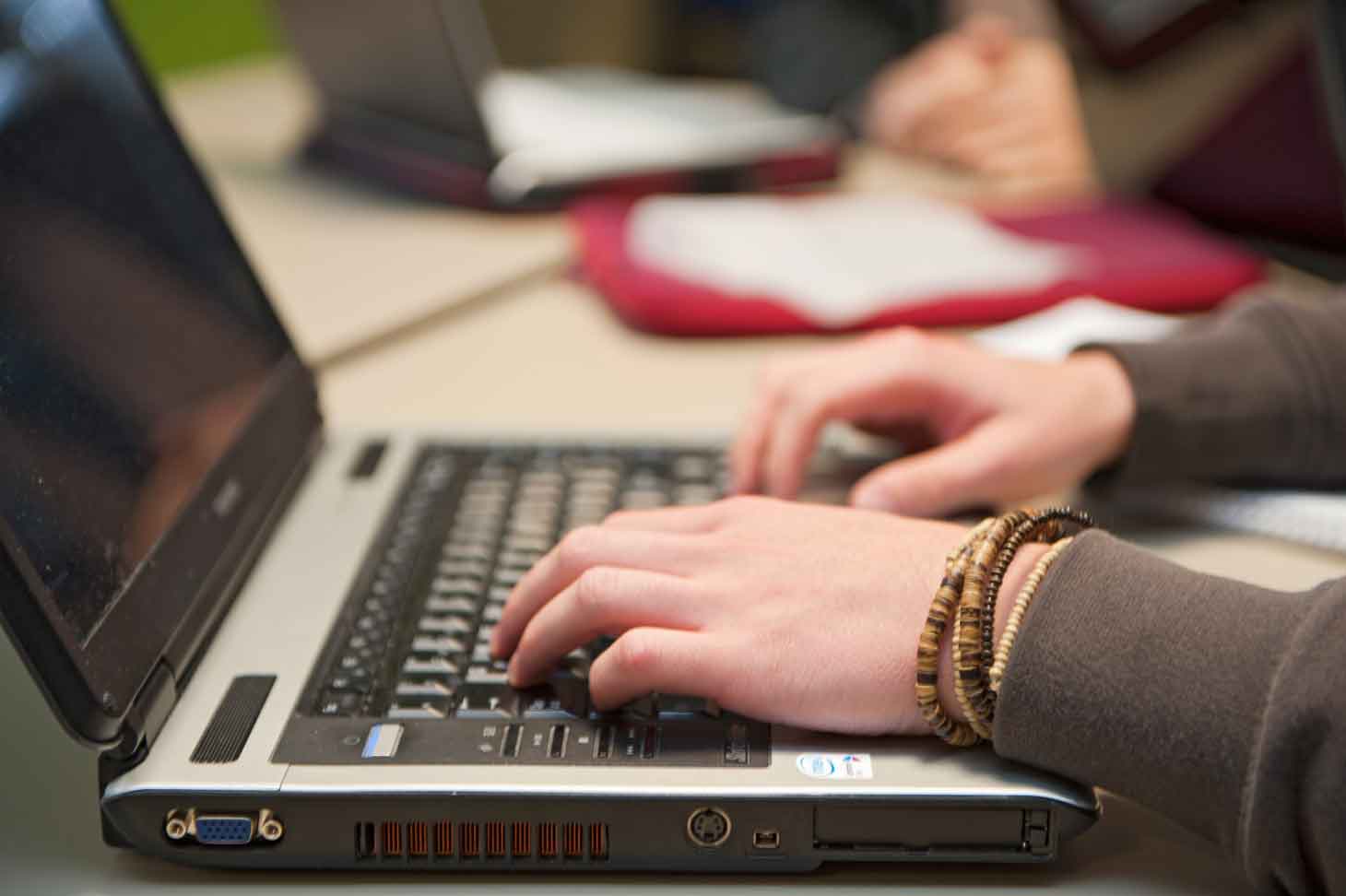 Hände auf Laptop-Tastatur
