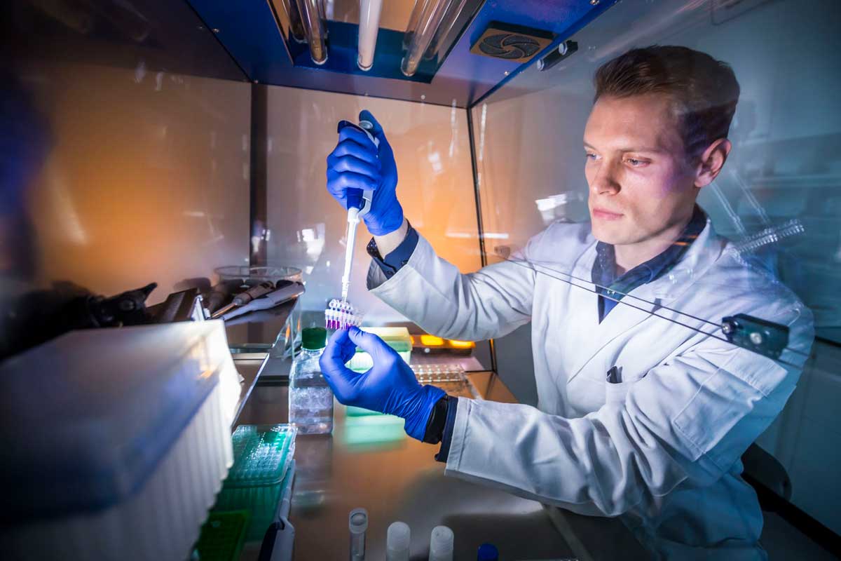 Student mit Pipette im Labor