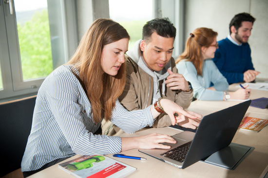 Studierende arbeiten am Laptop