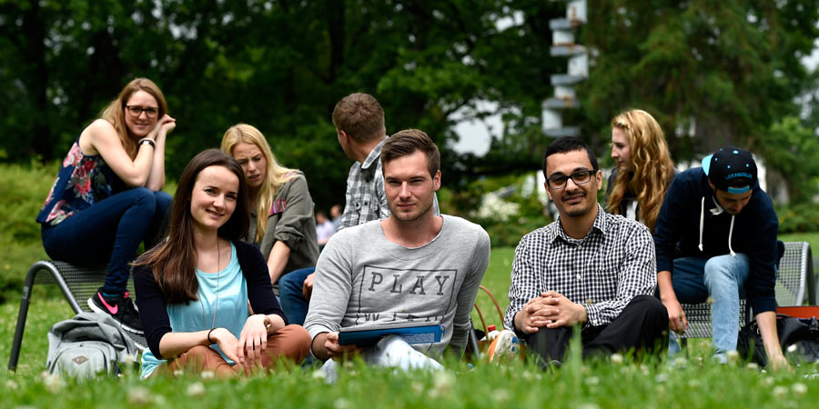 Studis auf dem Campus im Gras