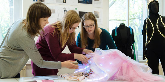 Studentinne bestücken ein Kleid mit digitalen Leucht-Elementen