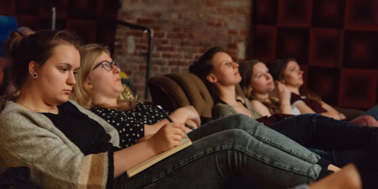 Studentinnen sitzen im Kino und analysieren das Gezeigte