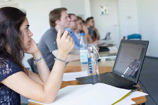 Studentin mit Laptop in Seminarraum