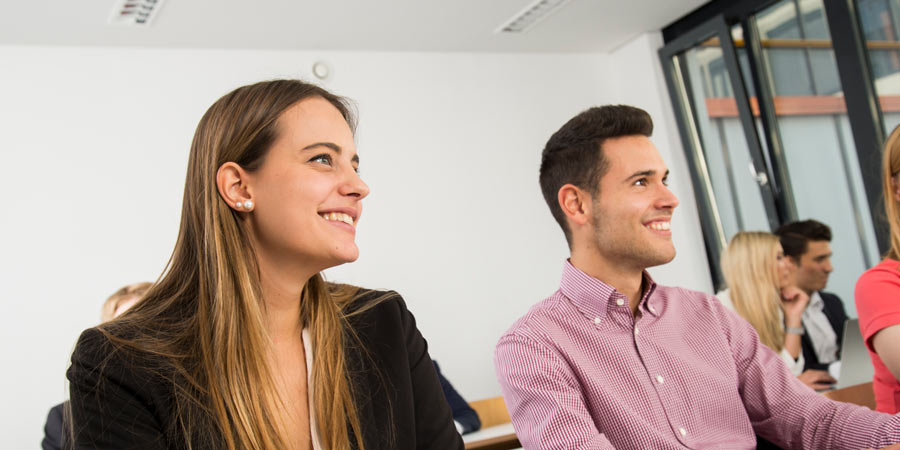 Student und Studentin im Seminar, lachend