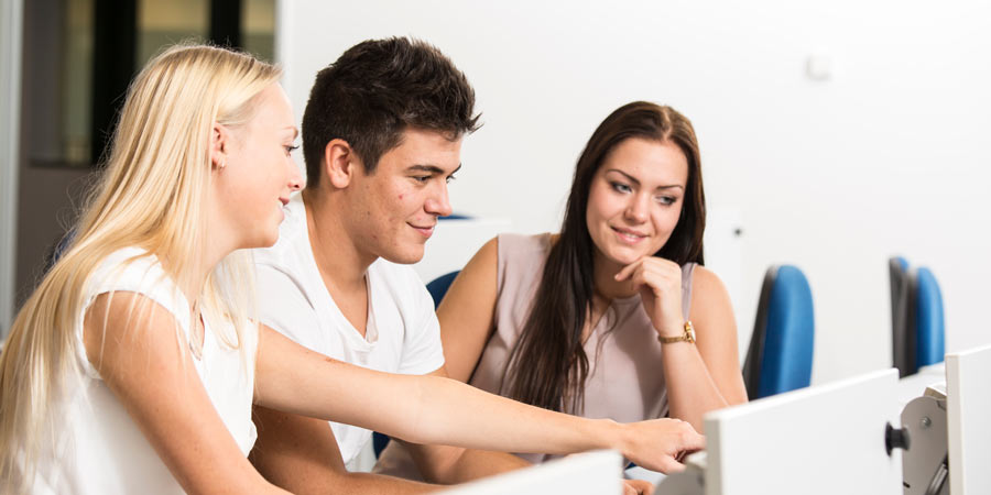 Zwei Studentinnen und ein Student arbeiten gemeinsam