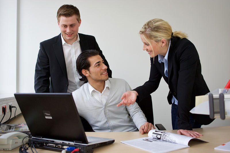 3 Studierende vor Laptop im Gespräch