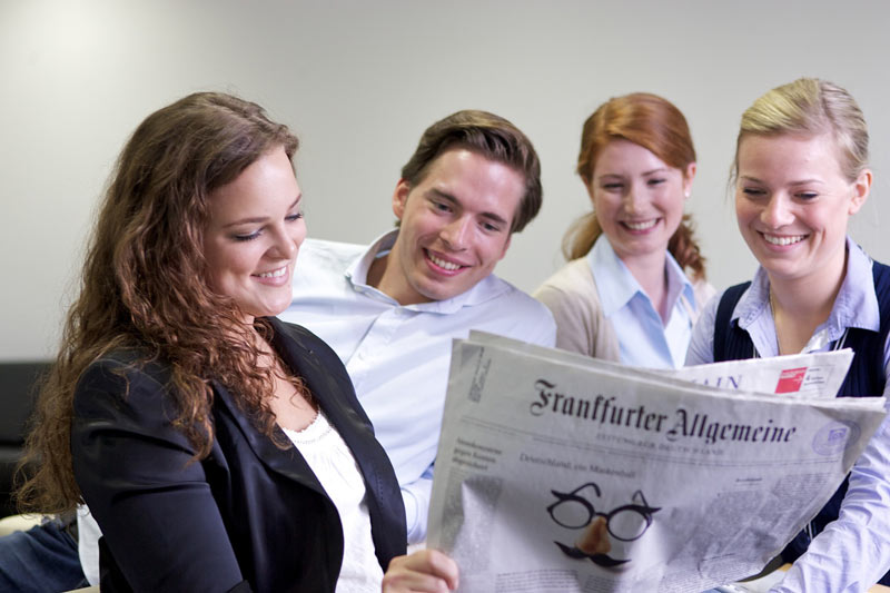 4 Studierende gucken gemeinsam in Tageszeitung