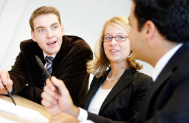 3 Studierende nebeneinander am Tisch im Gespräch