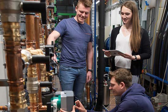 Zwei Studenten und eine Studentin an Maschinen