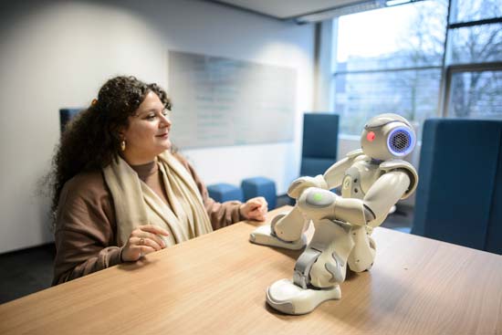 Frau mit Roboter am Tisch