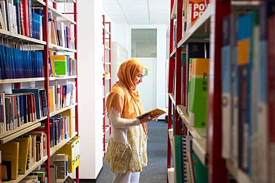 Eine Studentin liest in der Bibliothek.