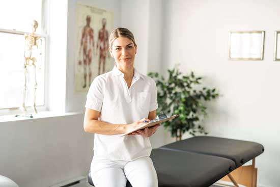 Frau sitzt auf Therapieliege