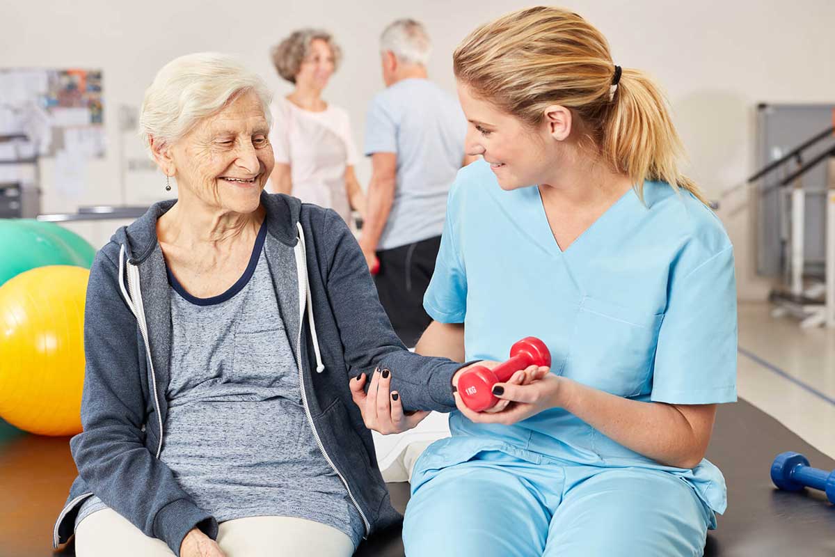 Therapeutin gibt Patientin Hantel