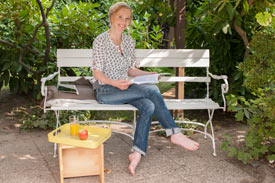 Frau auf Gartenbank mit Lehrmaterial