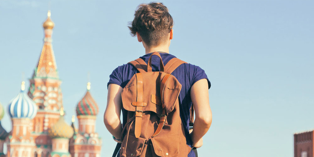 Eine Person mit Rucksack mit der Basilius-Kathedrale im Hintergrund