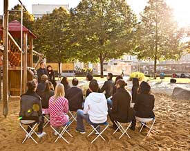 Gruppe sitzt in Sandkasten