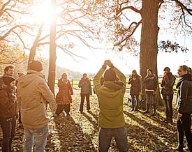 Studierende stehen im Kreis im Wald