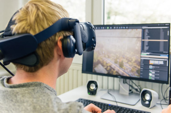 Student mit VR-Brille vor dem Gaming-PC