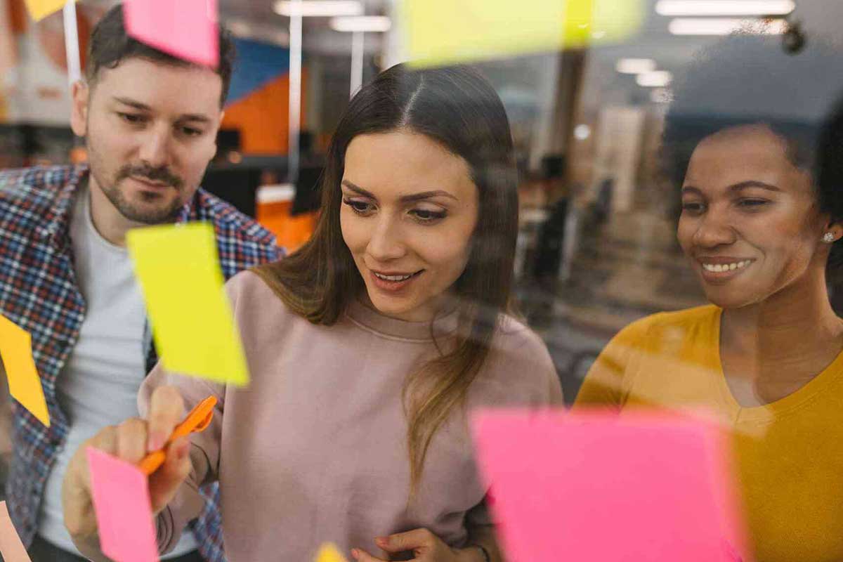 Studierende betrachten bunte Klebezettel