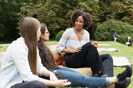 3 Studentinnen draußen auf Wiese