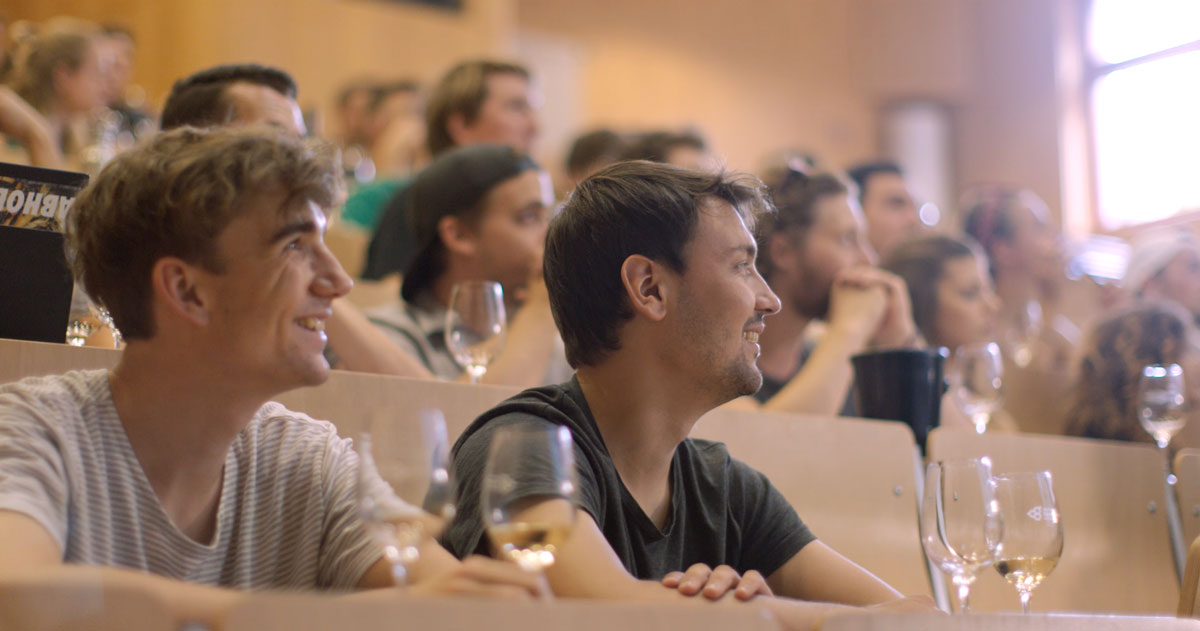 Studierende mit Weingläsern im Hörsaal