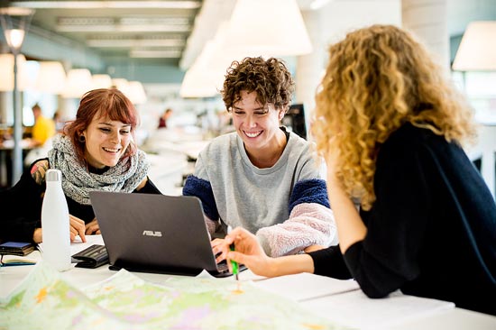 Studierende arbeiten an Laptop