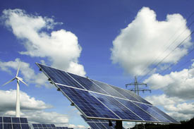 Erneuerbare Energie: Solarzellen und Windrad im Hintergrund