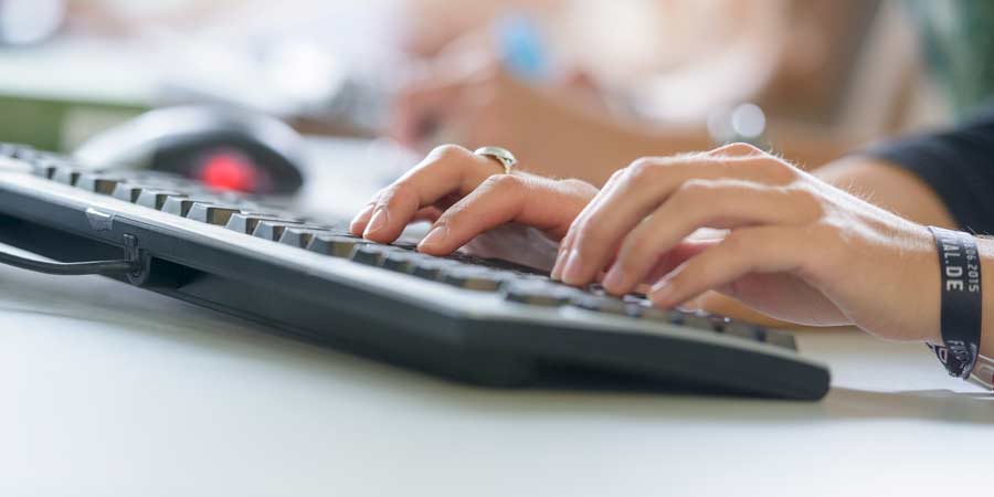 Hände tippen auf eine Tastatur