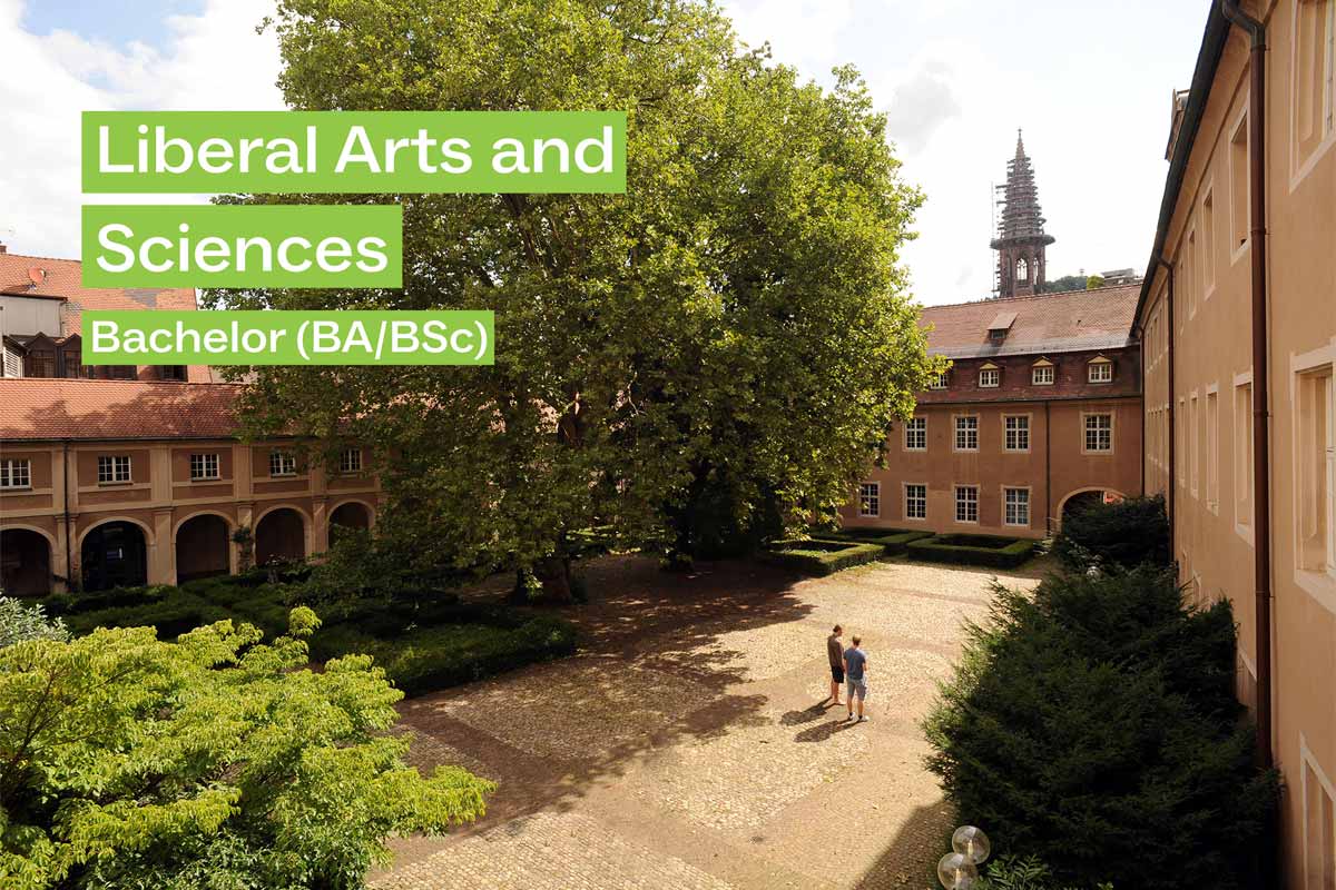 2 Studierende in einem Innenhof an der Universität Freiburg