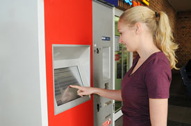 Junge Frau am Fahrkartenautomat der Deutschen Bahn