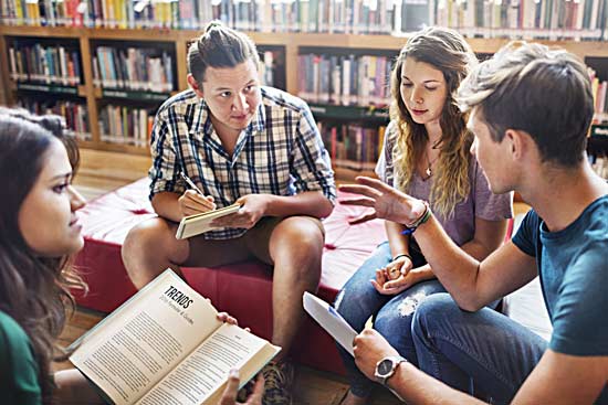Studierende diskutieren in der Bibliothek