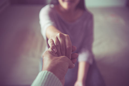 Psychologe reicht einer Patientin die Hand