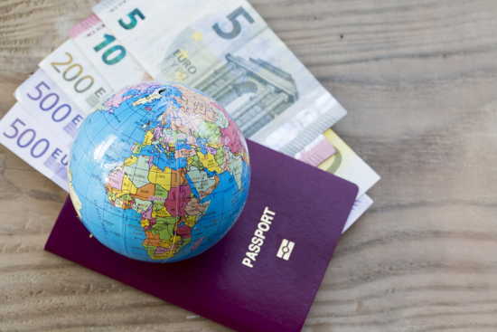 Pass, Globus und Geld auf einer hübschen Holzlatte als Hintergrund